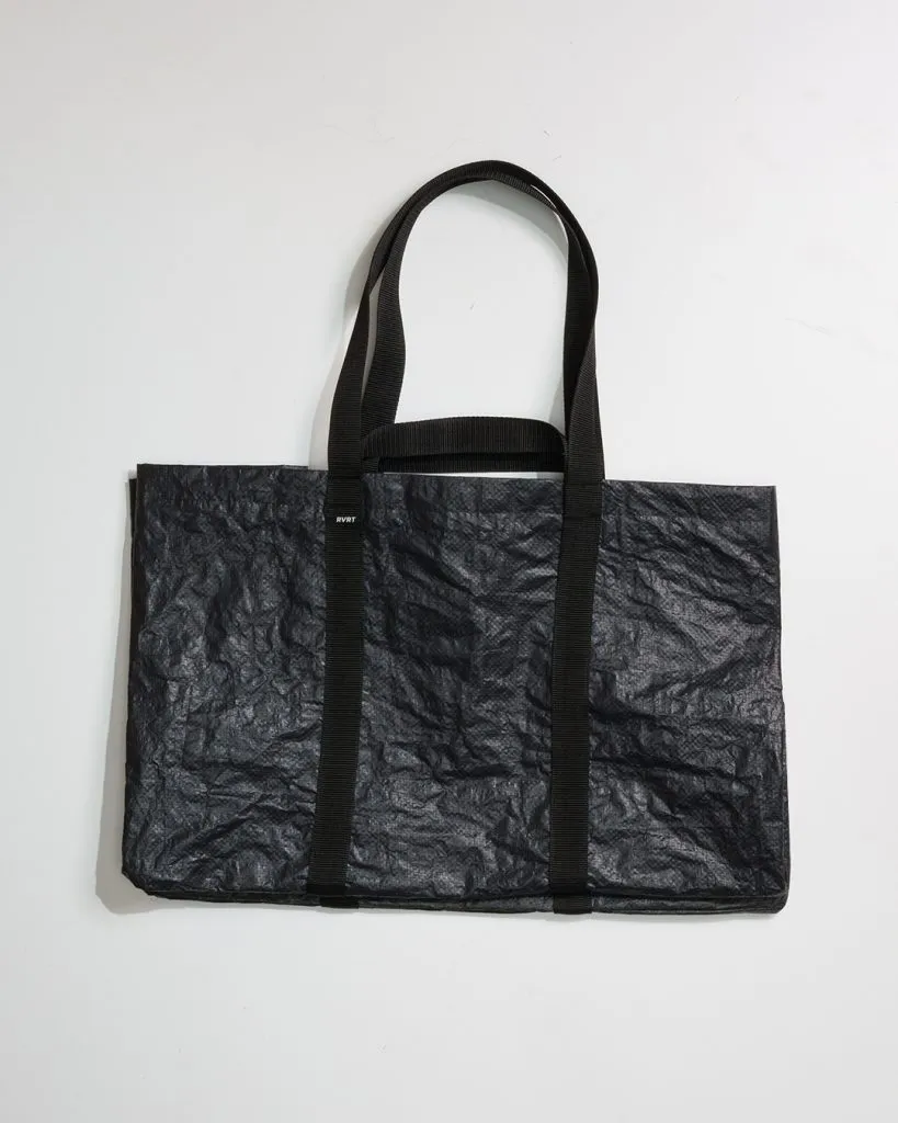 Black crumpled bag with two handles on white background.
