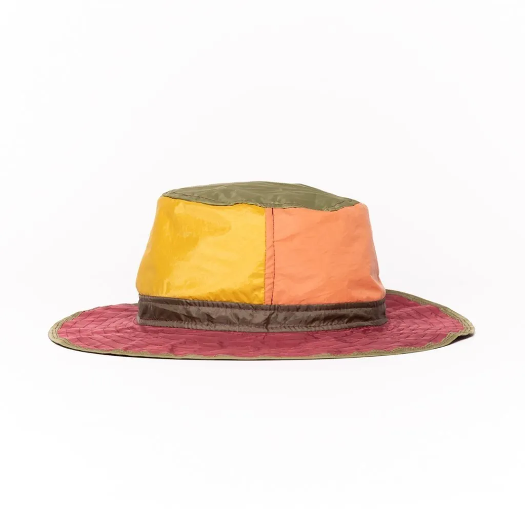 Vibrant upcycled hat with multicolored panels and wide brim.
