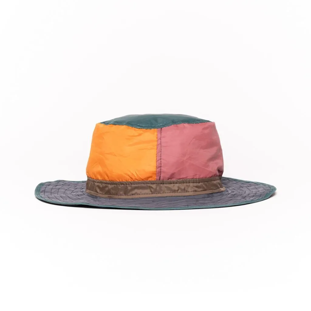 Vibrant patchwork hat with colorful panels and wide brim.